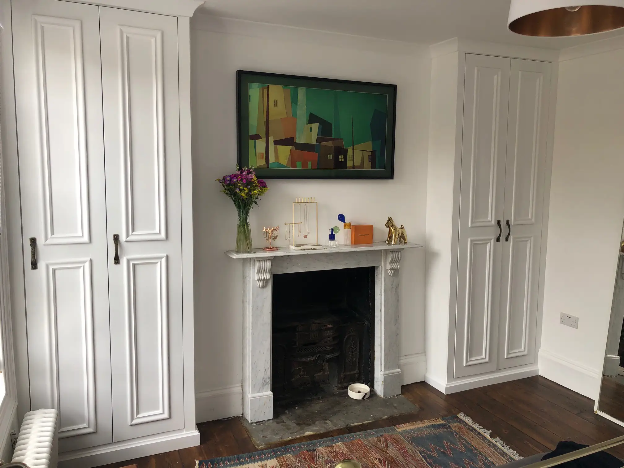 Bespoke alcove fitted white floor to ceiling wardrobes.