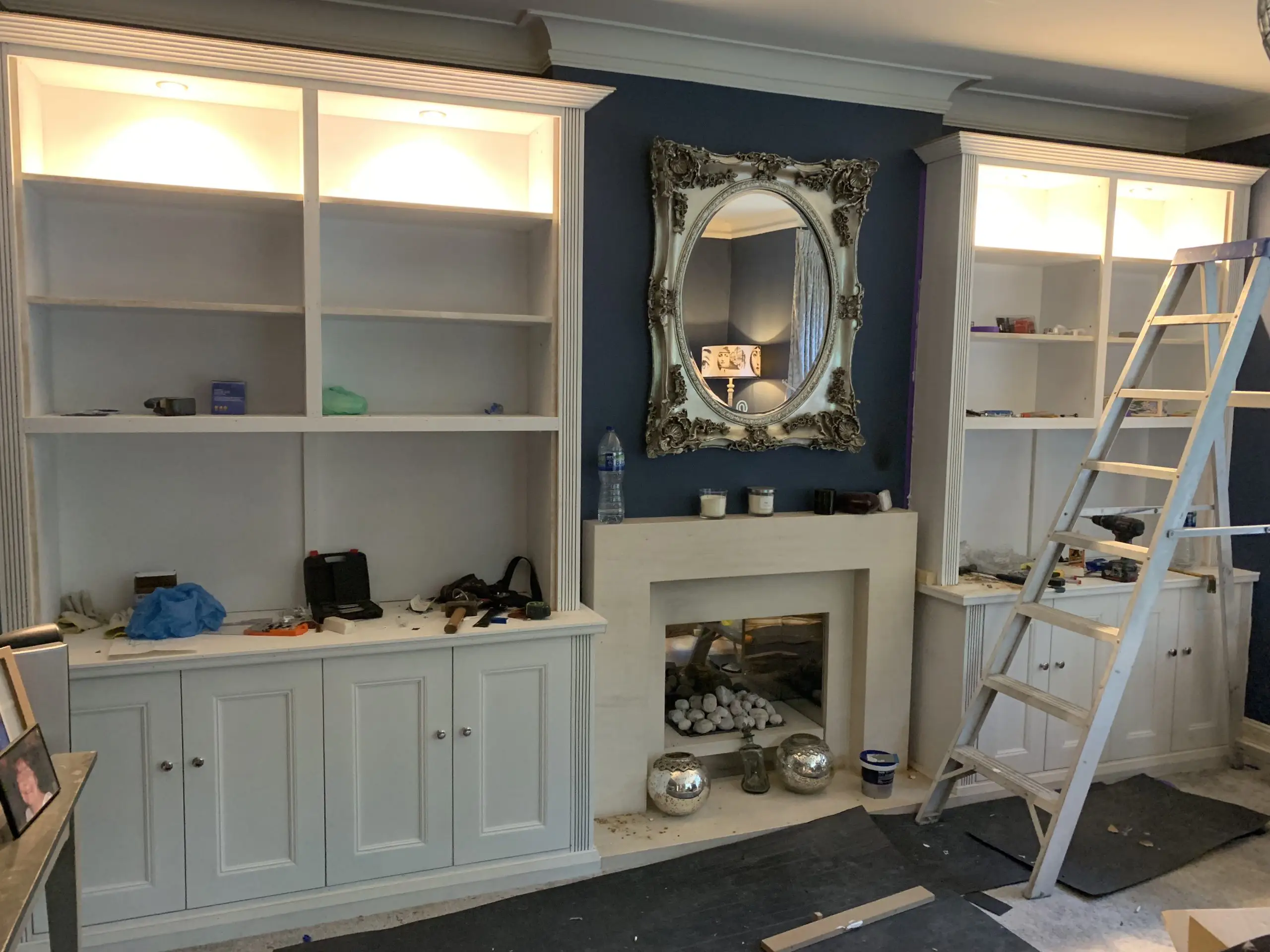 Cabinet unit with downlighting and bottom storage cabinets in progress, being built.