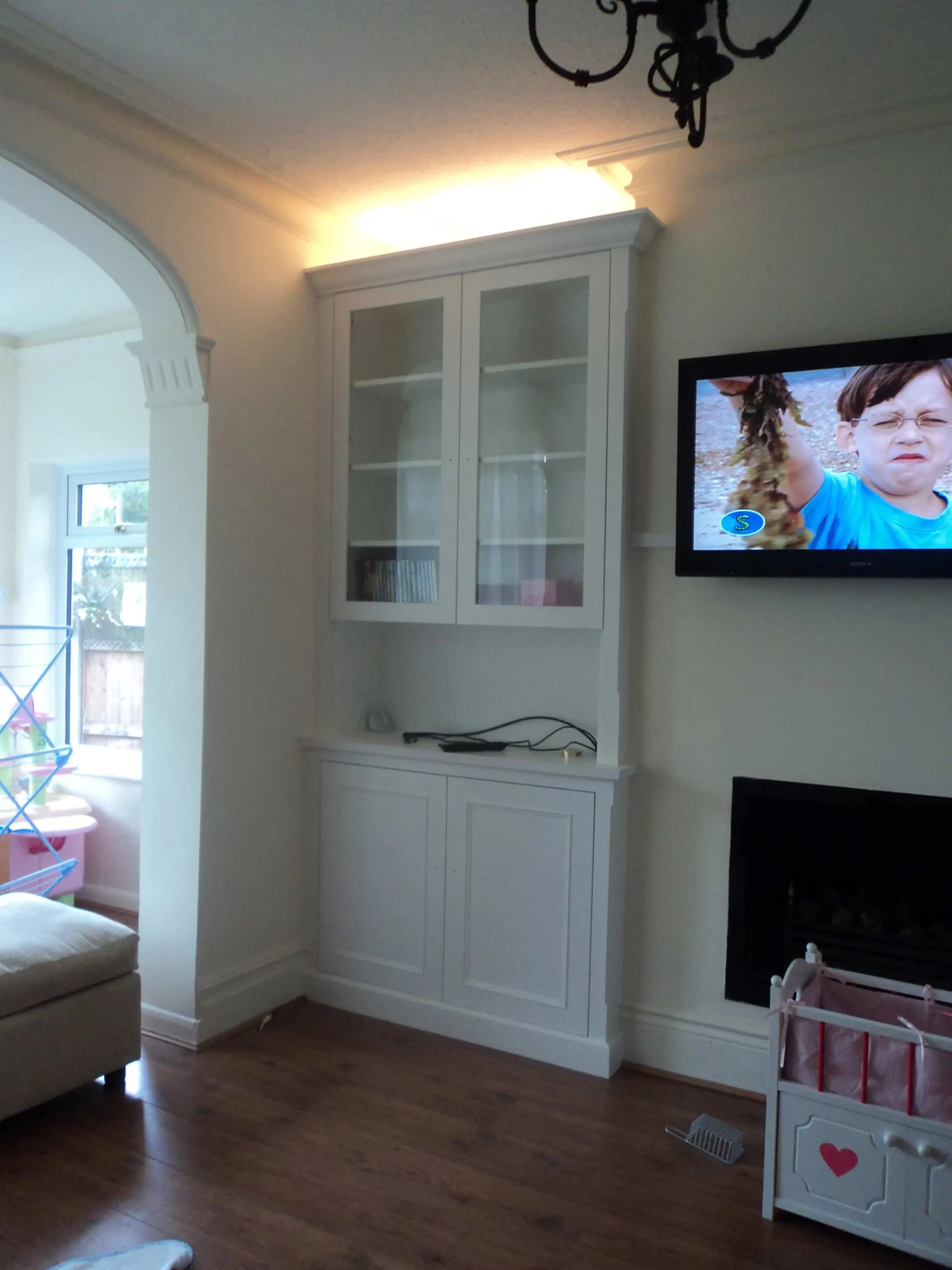 Classic alcove cabinet with up-lighters and glass doors.