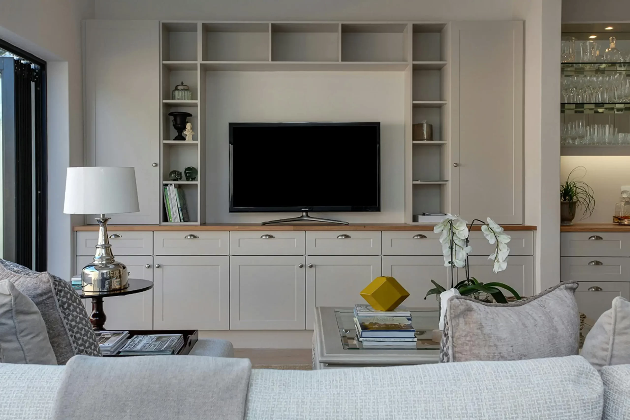 bespoke custom tv cabinet unit in grey with open shelves and cabinets.