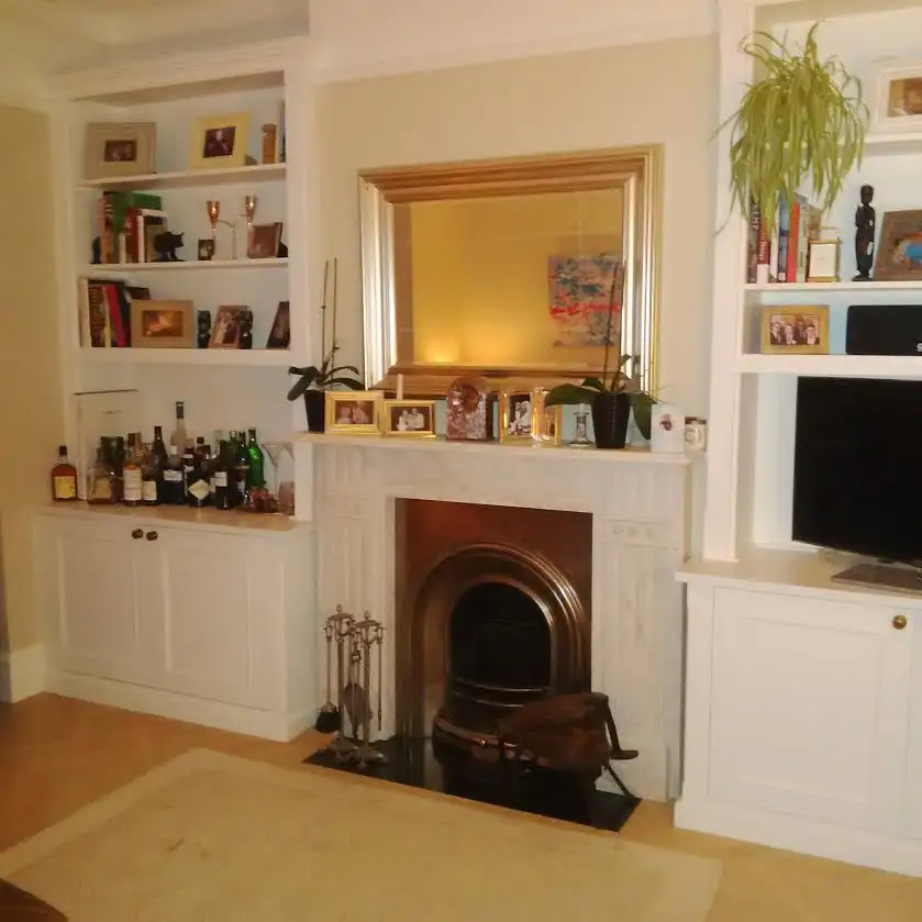 A pair of white built in base cabinets with bookcases above for display and books in Dulwich London.