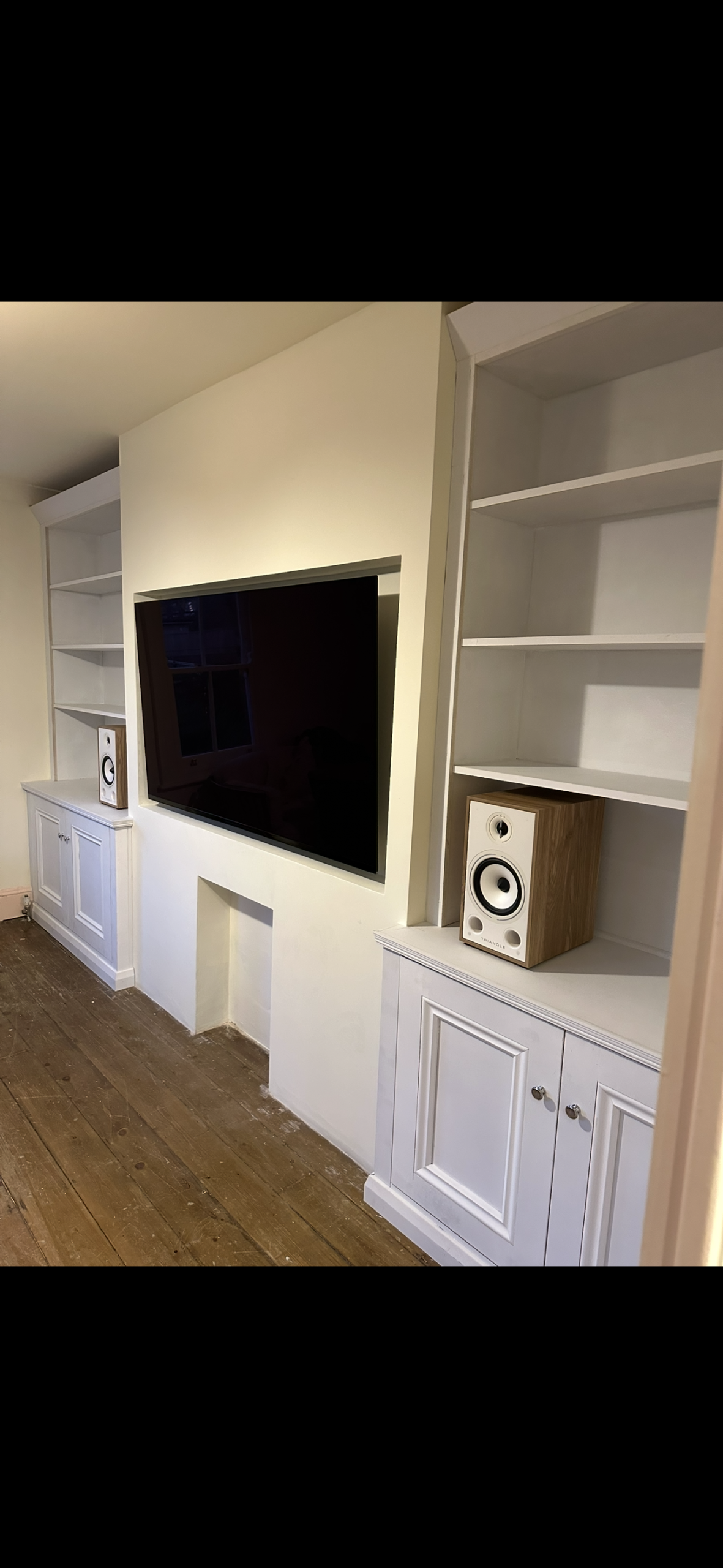 Pair of fitted alcove cabinets with bookcase shelving above.